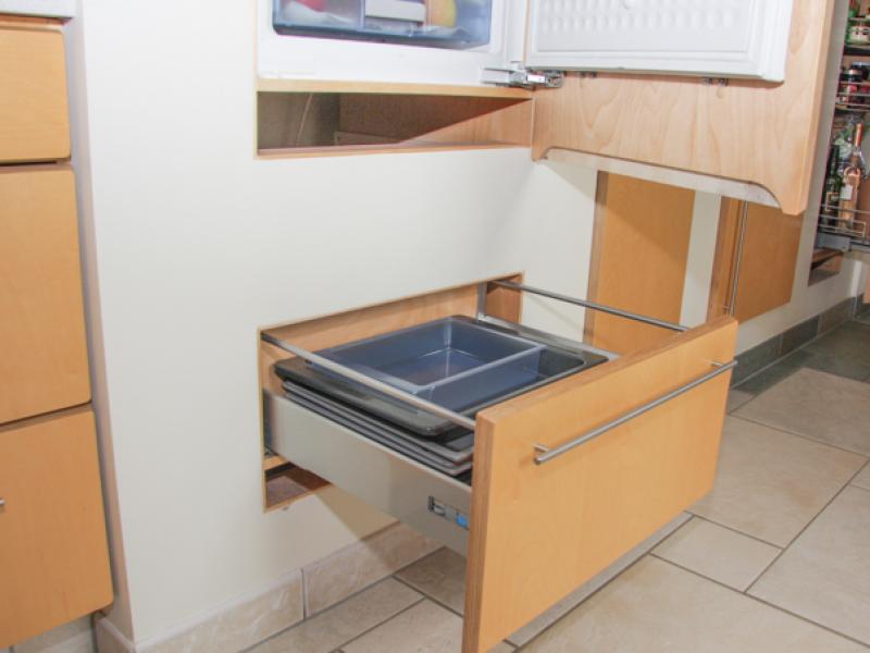 In die Wand integrierte Elemente Kühlschrank und ausziehbare Stauraum-Schublade in die Wand integriert, rechts: Vorratsauszug